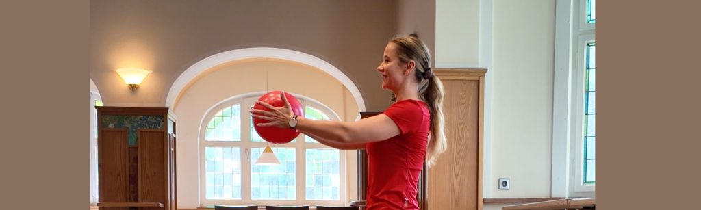 Franziska Erdmann leitet lachend einen zertifizierten Präventionskurs nach § 20 SGB V mit dem Gymnastikball in Stuttgart-Weilimdorf und Korntal.